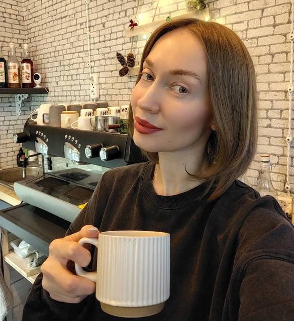 Бариста кофейни «Кофе и Книги» с чашкой кофе