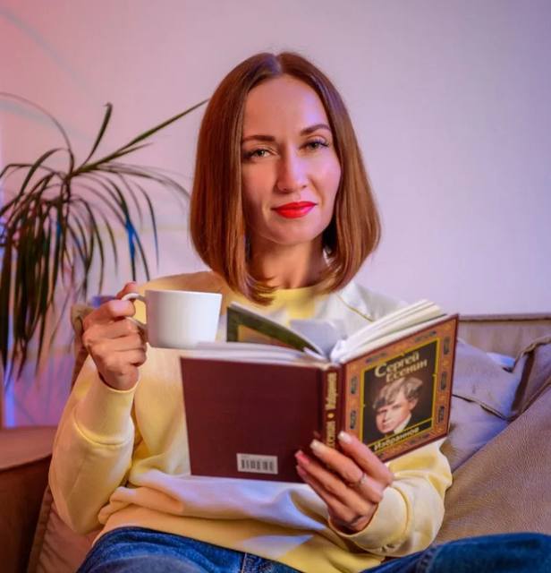 Гостья кофейни читает книгу за чашкой кофе